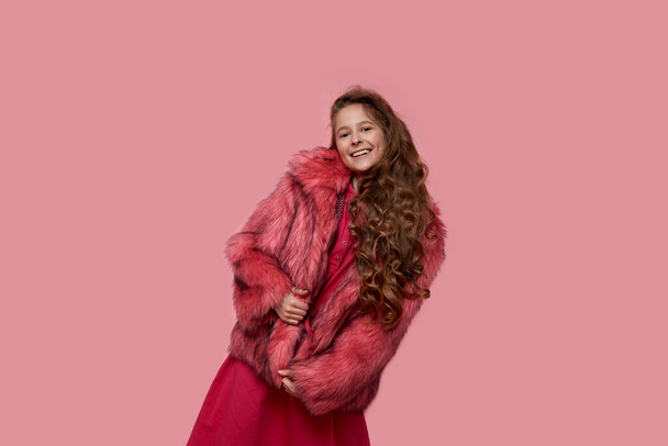 girl fashion model in fashionable clothes, light pink fur coat on studio - Fotó, kép