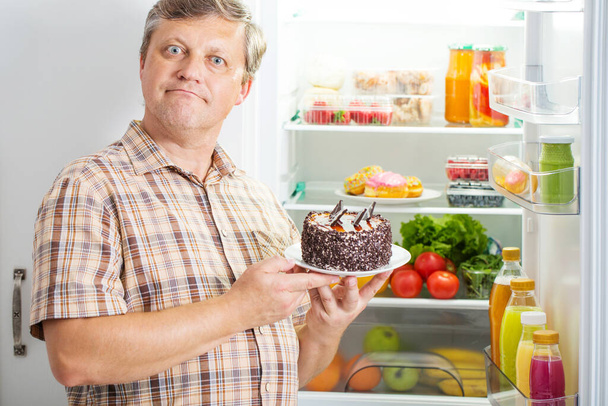 mature men at fridge  with food - Zdjęcie, obraz