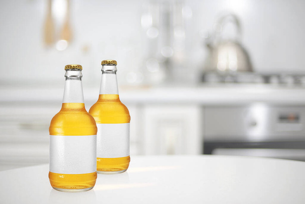 Zwei Bierflaschen mit langem Hals und leerem Etikett auf dem Küchentisch. Design-Attrappe - Foto, Bild