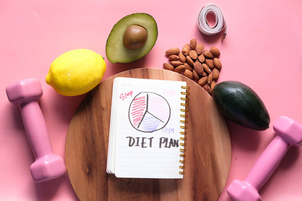 handwritten diet plan on notepad with healthy fruits on pink background  - Photo, image