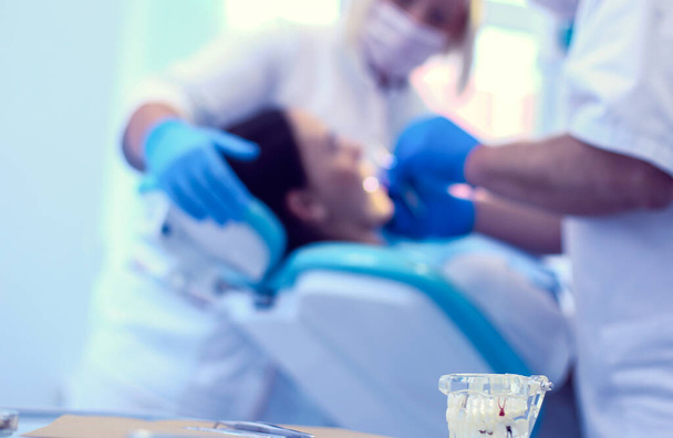 Retrato de un dentista que trata los dientes de una paciente joven - Foto, imagen