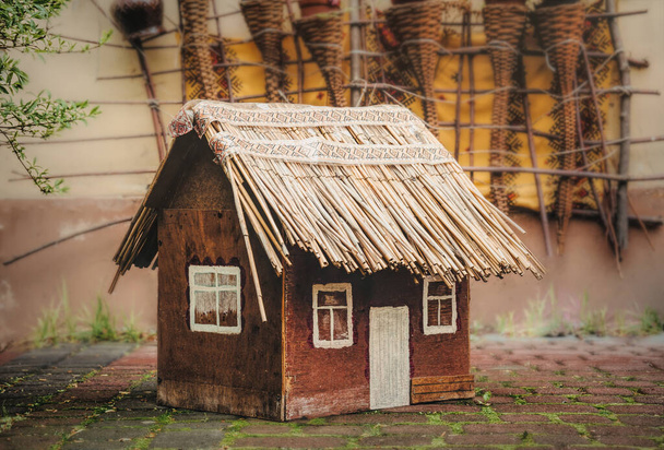 Juguete casa de madera con techo de paja
 - Foto, imagen