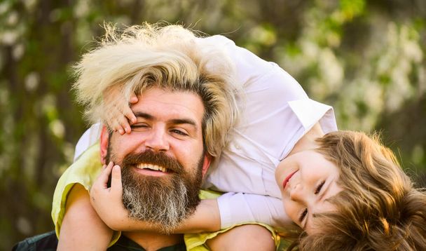 Bearded brutal man good father. Dad and son. Little son. Spring walk. Fatherhood. Happy family. Fathers day. Little boy and father in nature background. Hipster and baby son in blooming garden - Fotoğraf, Görsel