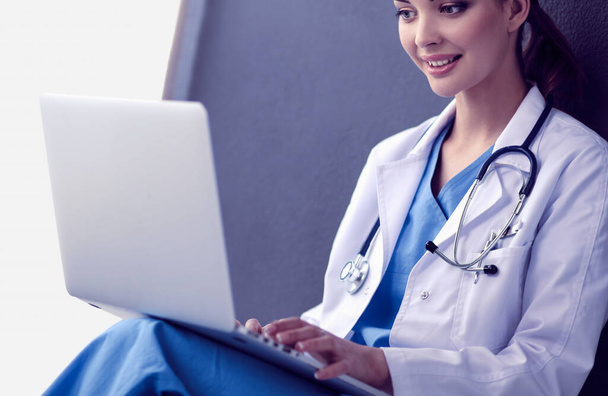 Female doctor sitting and working a laptop - Φωτογραφία, εικόνα