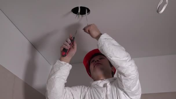 Férfi villanyszerelő javítás mennyezeti lámpa - Felvétel, videó