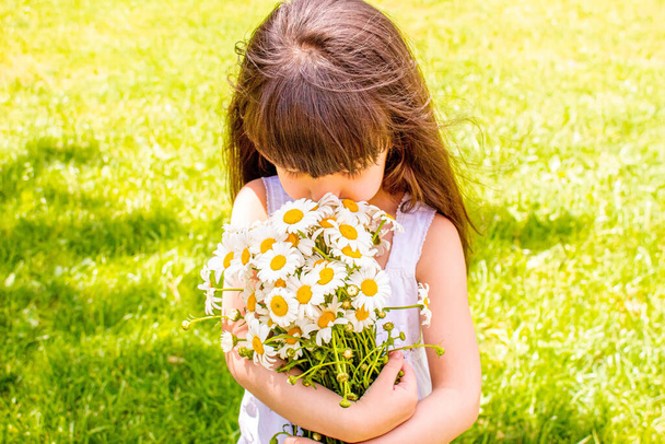 Girl with daisies in hands on the field. Selective focus.flower - Fotó, kép