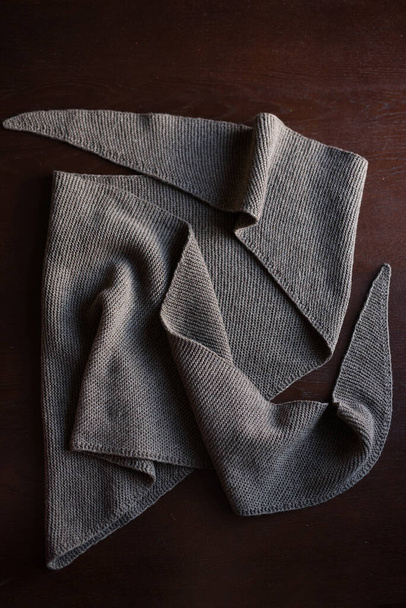 sciarpa triangolare marrone lavorato a maglia si trova sul tavolo, tavolo texture marrone
 - Foto, immagini
