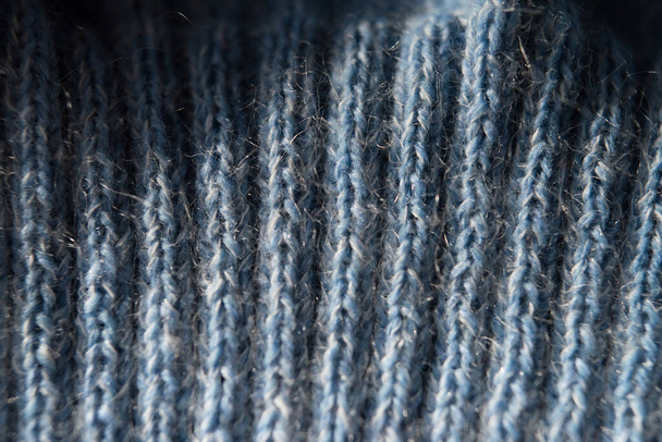 textured knitting pattern with woolen threads of blue color, close-up, top view, knitted lines and patterns - Photo, image