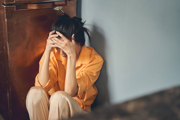 Upset young woman sitting on the floor at home - Photo, Image