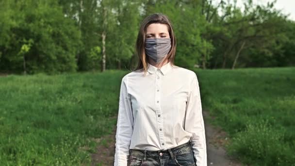 Medical mask, protection against coronavirus. End of pandemic. Portrait of a woman outdoors - Felvétel, videó