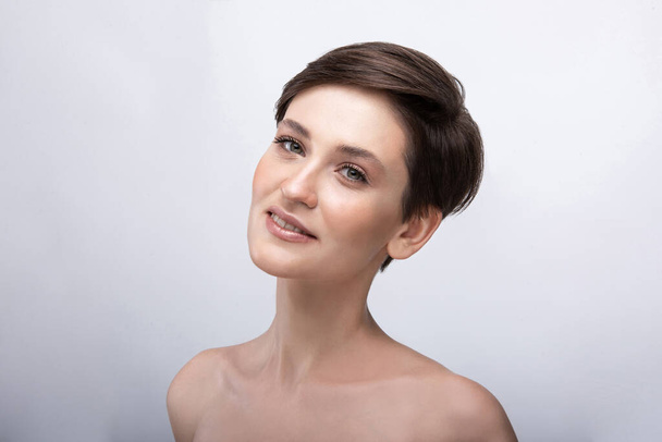 Portrait of a young girl with a long neck, almost no makeup on her face, photo without retouching, natural makeup and vivid emotions, smile and joy in the look - Photo, Image