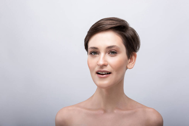 Portrait of a young girl with a long neck, almost no makeup on her face, photo without retouching, natural makeup and vivid emotions, smile and joy in the look - Foto, imagen