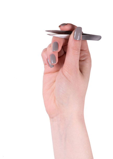 Female hand holding tweezers - Foto, imagen