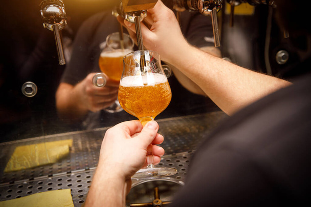 Primer plano del camarero vertiendo cerveza ligera de barril en vidrio
 - Foto, Imagen