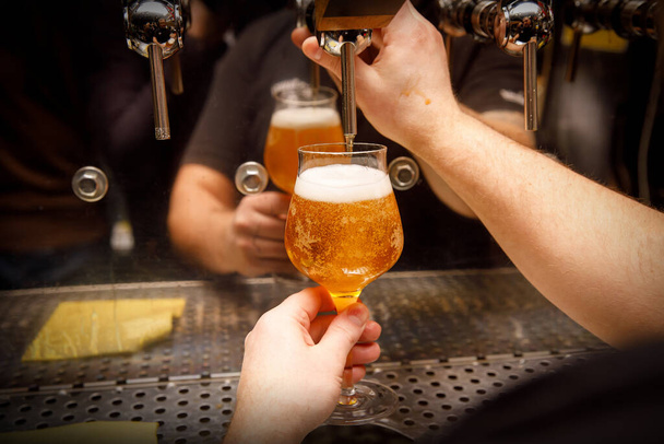 Bartender, mão Barman na torneira de cerveja derramando cerveja artesanal
 - Foto, Imagem