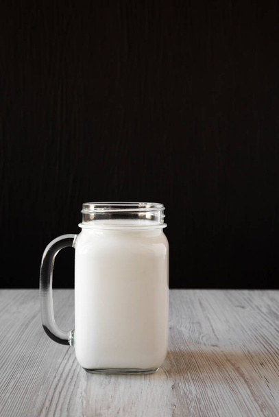 Coconut milk in a glass jar mug, side view. Copy space. - 写真・画像