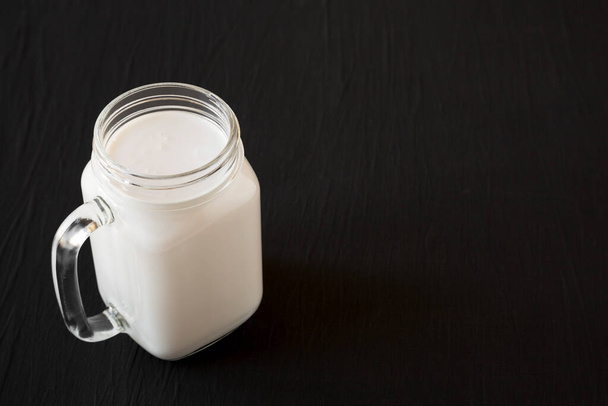 Coconut milk in a glass jar mug, side view. Space for text. - Foto, Imagen