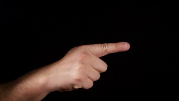 Zeigefinger auf schwarzem Hintergrund. Großaufnahme einer männlichen Handbewegung - Filmmaterial, Video