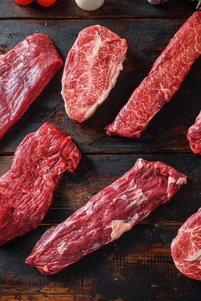 Alternative viande de bœuf coupée jupe steak fermer devant d'autres coupes en boucherie sur la vieille table en bois vue de dessus vertical
. - Photo, image