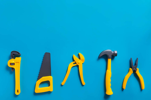 Toys background. Top view of toy tools on blue background with copy space for text. - Foto, imagen
