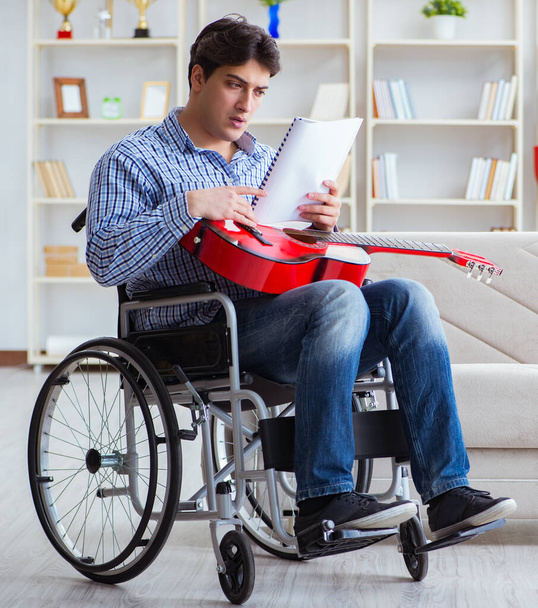 інвалідний чоловік грає на гітарі вдома
 - Фото, зображення