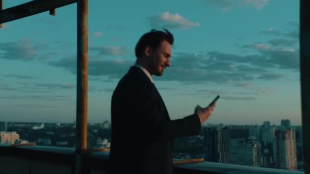 top manager uses a smartphone with a view of the city - Materiał filmowy, wideo
