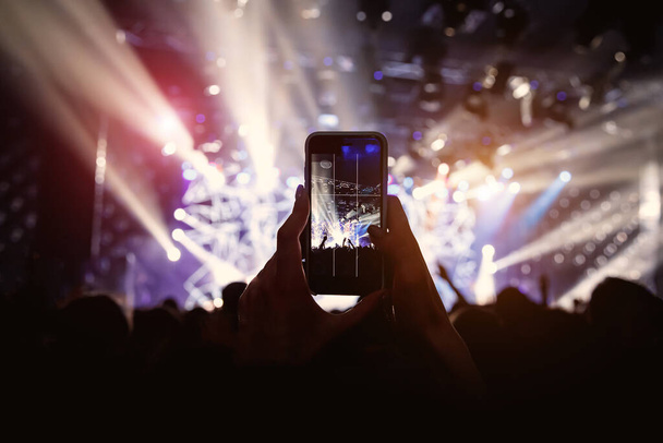 Фото для социальной сети на концерте. Мобильный телефон на музыкальном шоу
 - Фото, изображение