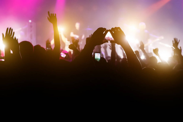 Multitud con las manos levantadas y smartphone grabar un concierto
 - Foto, imagen