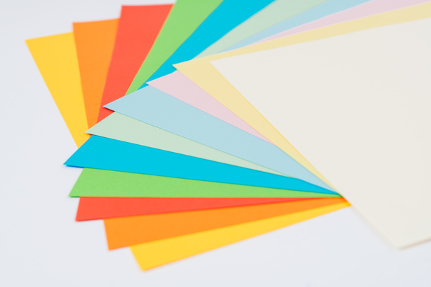 laid out bright multicolored paper on white background, flat lay - Foto, Imagem