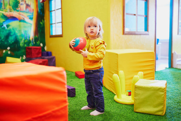 Adorable little girl in kindergarten, daycare or preschool. Toddler having fun in cafe with playing zone. Indoor activities for small kids - Фото, зображення