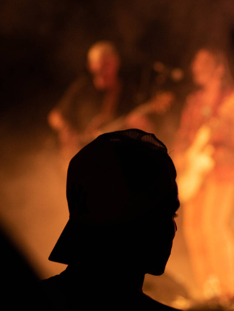 Silhouette di uomo con un cappello in un concerto. Concentrazione selettiva. Copia spazio
. - Foto, immagini