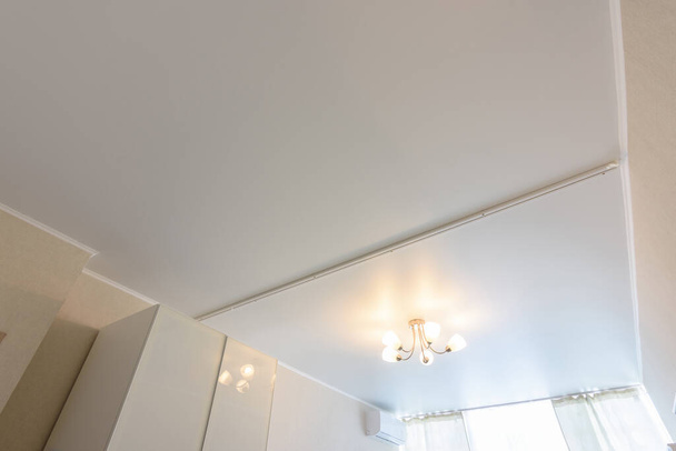 Clássico teto falso fosco branco com separação para cortinas em duas metades
 - Foto, Imagem