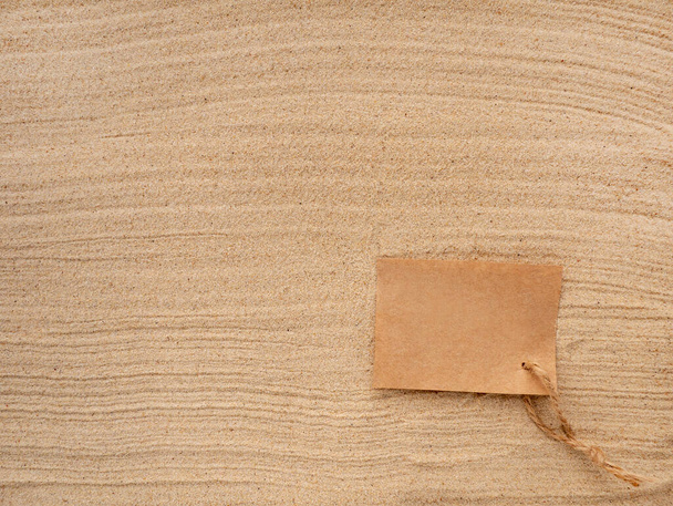 Kumsalda bir mektup. Deniz kumunun dokusunda sicim olan el işi kağıt. - Fotoğraf, Görsel