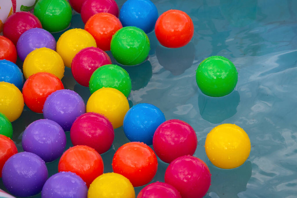 Πολύχρωμες πλαστικές μπάλες σε μια πισίνα. Παιχνίδια - Φωτογραφία, εικόνα