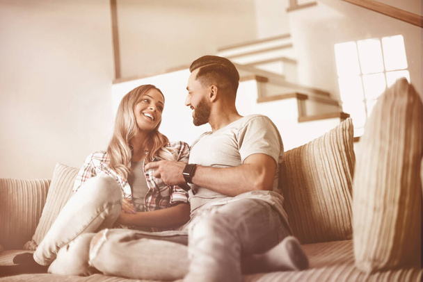 loving couple sitting on sofa in cozy living room - Photo, Image