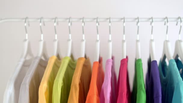  Lähikuva värikkäitä t-paitoja ripustimet, vaatteet tausta, liukusäädintä laukaus - Materiaali, video