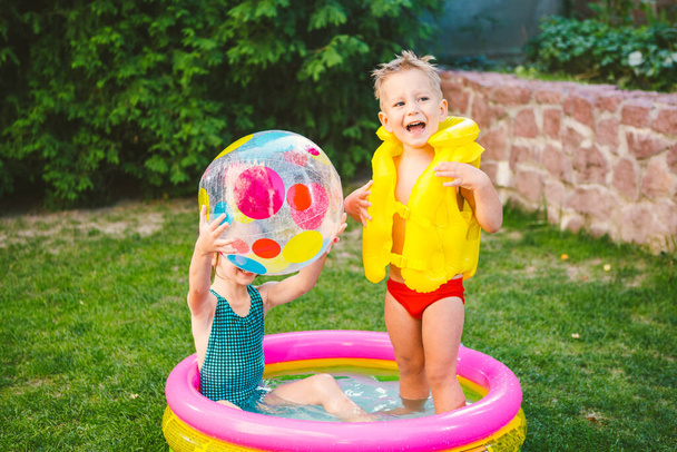 Felfújható medence. Nyári vakáció. Vízi játékok. Szabadidő a hátsó kertben. gyermekek fürdés egy felfújható szabadtéri medence és játszani Color Beach Ball. Egészséges gyermekek nyári tevékenység. - Fotó, kép