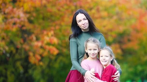 Nuori äiti ja hänen kaksi pientä tytärtään syksyllä puistossa
 - Materiaali, video
