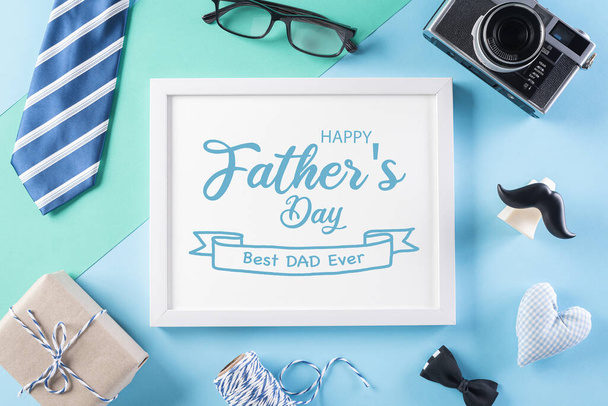 Happy Fathers Day taustakonsepti, jossa on kuvakehys, retro-kamera, koristeltu rusetti, solmio, silmälasit, lahjapakkaus ja viikset kirkkaalla pastellitaustalla
. - Valokuva, kuva