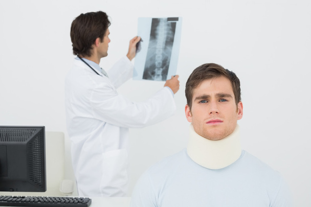 Male doctor explaining spine x-ray to patient - Foto, afbeelding