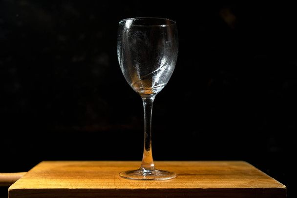 glass goblet on black background on wooden table - Photo, Image