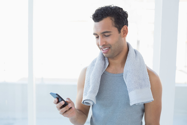 Young smiling man looking at mobile phone - Photo, Image