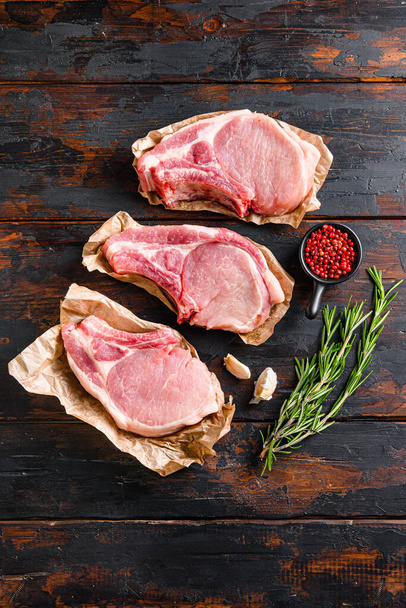 Barbekü domuz eti porsiyonu, otlar ve kabarık dikey manzaralı eski ve koyu ahşap masa üzerine kurulmuş.. - Fotoğraf, Görsel