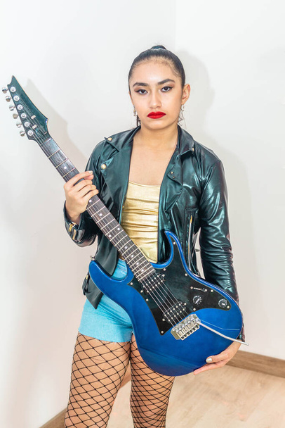 Portré tinédzser lányról elektromos gitárral. Karantén alatt végzett tevékenységek - Fotó, kép