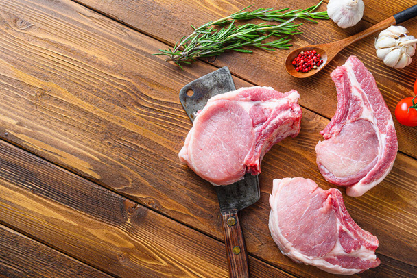 Сире м'ясо свинини нарізається травами та спеціями з м'ясом американського розморожувача на дерев'яному фоні для тексту. Діагональ
. - Фото, зображення