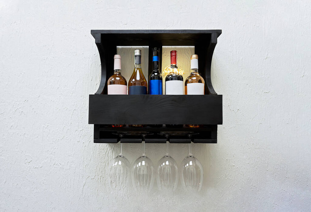 Набір пляшок і келих елітного червоного вина на дерев'яній полиці
 - Фото, зображення