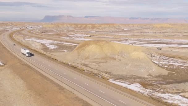 AERIAL: Flying above a big rig hauling a freight container across wintry desert - Footage, Video