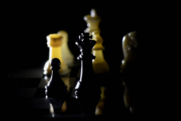 pezzi di scacchi su una scacchiera in una stanza buia illuminata da una lanterna
 - Foto, immagini