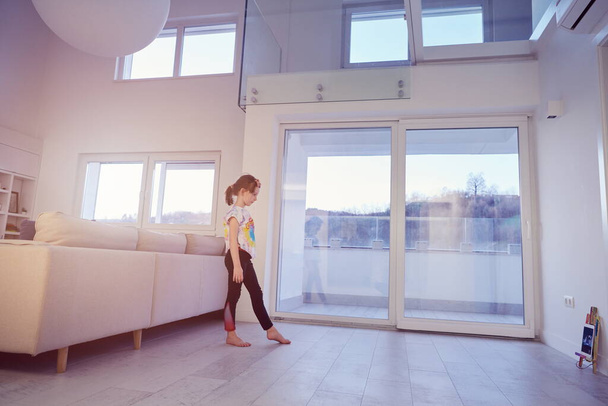 Маленькая девочка имеет онлайн-тренировки по планшету и делать современные балетные танцы упражнения дома. Концепция онлайн-образования в современной балетной школе. Социальная дистанция во время карантина, самоизоляция в коронавирусе
 - Фото, изображение