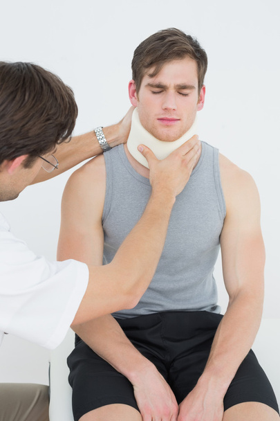 Male doctor examining a patients neck - Foto, Bild